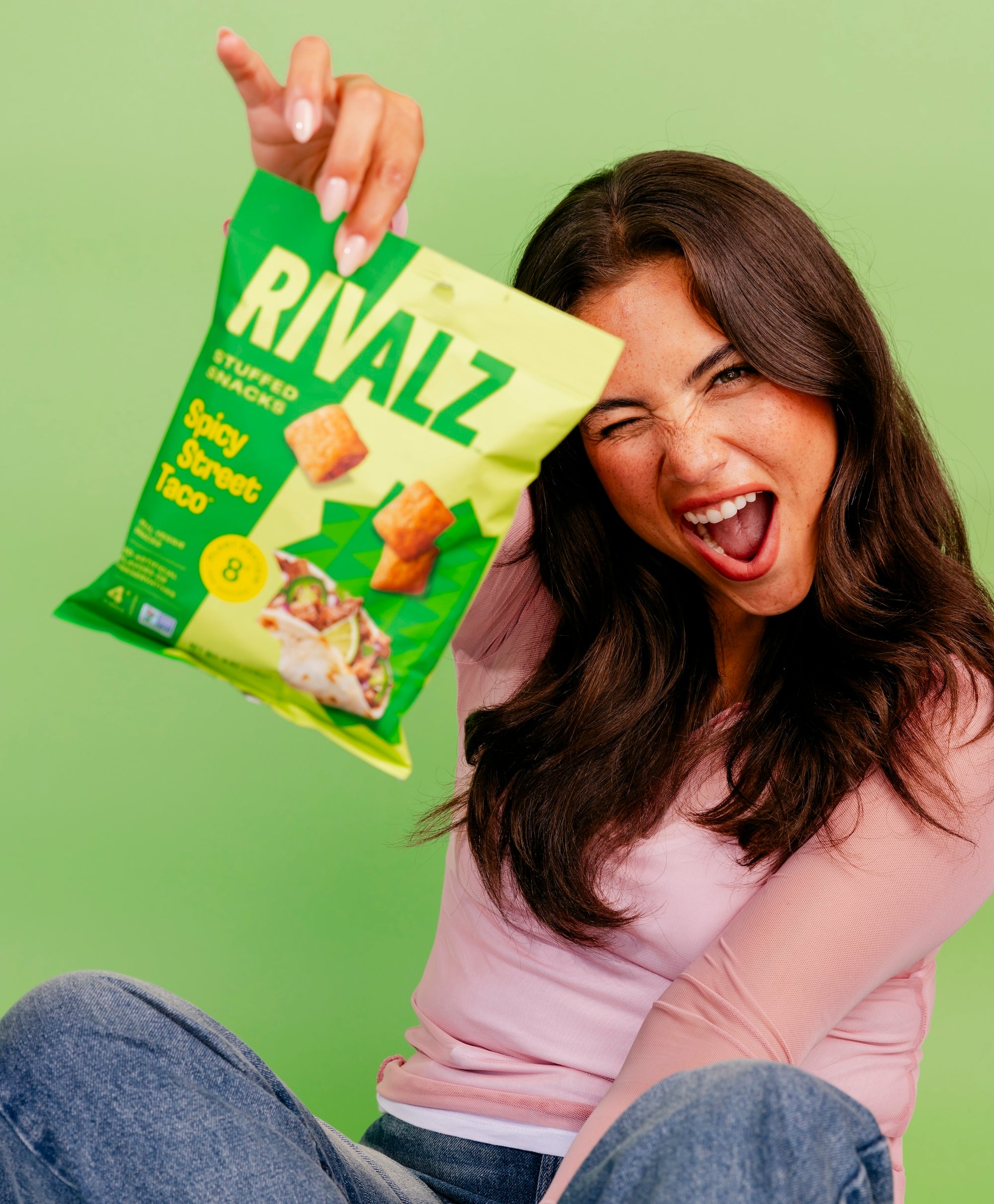 Skandia Shafer with a bag of Rivalz Spicy Street Taco vegan snack